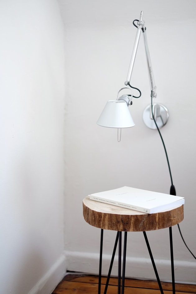 an industrial night stand with a while book.